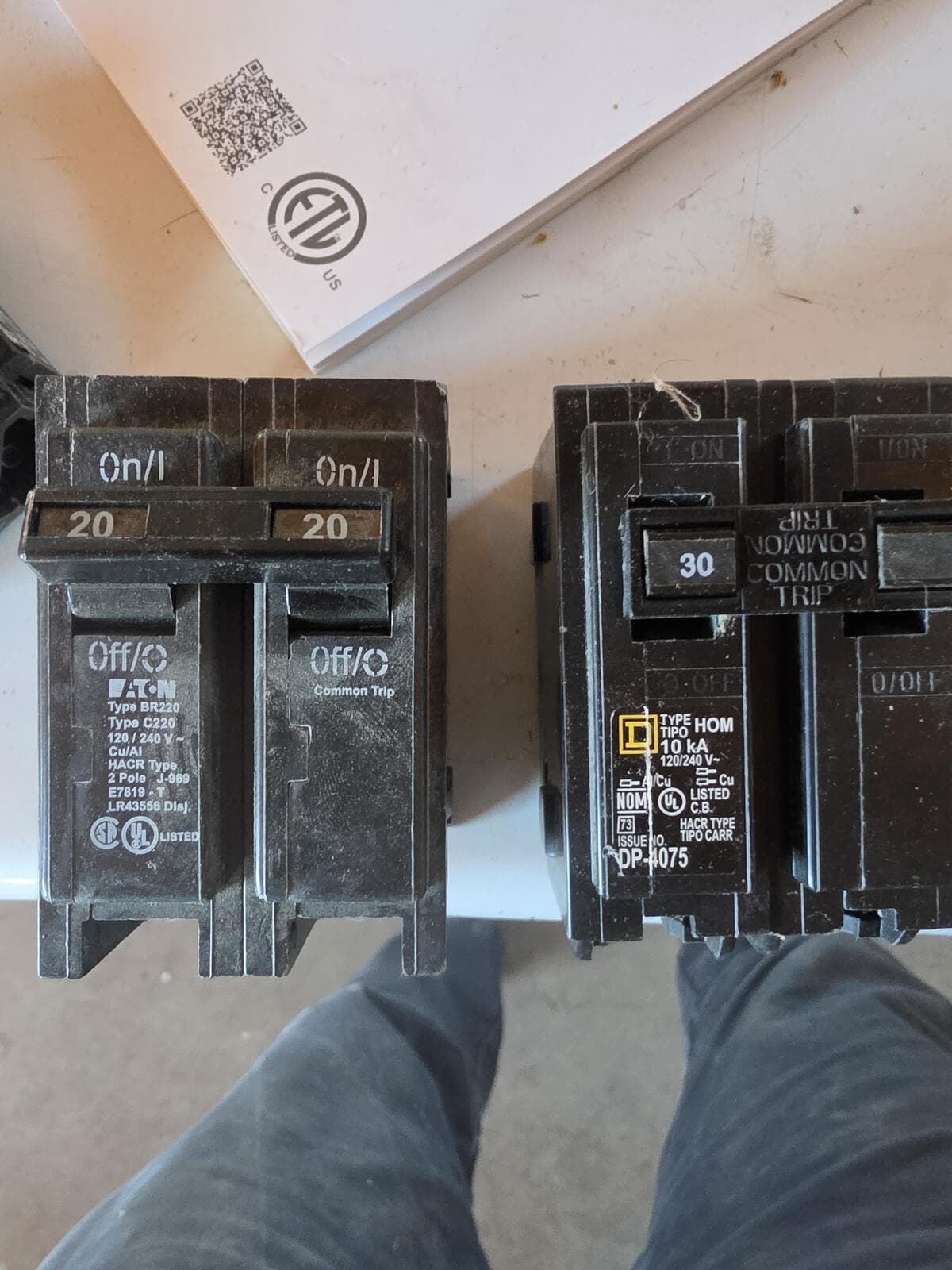 An Eaton BR 20A two-pole breaker beside a Square D HOM 30A two-pole breaker