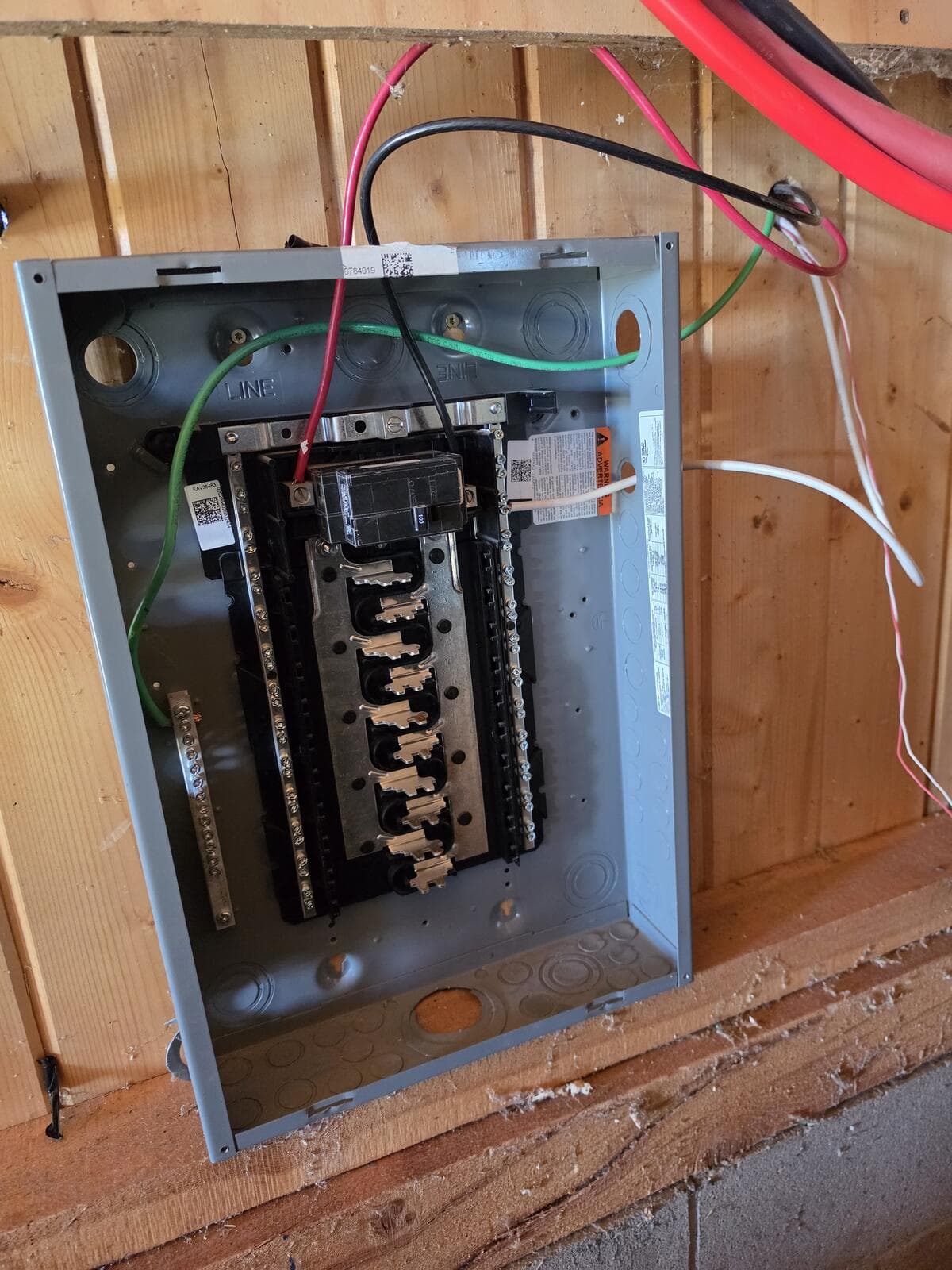 The same panel with generator wires landed on the main breaker, neutral bar and ground bar